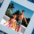 A framed fine art print featuring two vintage new kid on the block dolls, Jordan and Danny, dressed in retro swimwear, enjoying a tropical rooftop scene with palm trees and a bright blue sky in the background. One doll is lounging on a yellow beach chair while the other stands confidently with sunglasses and a braid. The vibrant colors and playful nostalgia make this a bold and quirky art piece.