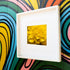 A framed fine art print featuring a soft-focus macro photograph of a golden-yellow flower, displayed against a vibrant, colorful graffiti wall. The contrast between the delicate floral image and the bold street art background creates a striking visual balance, making this piece perfect for modern and eclectic decor styles.